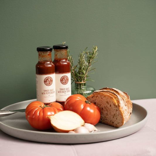 Bottle of Australian Pepperberry Tomato Sauce with fresh tomatoes and pepperberry leaves