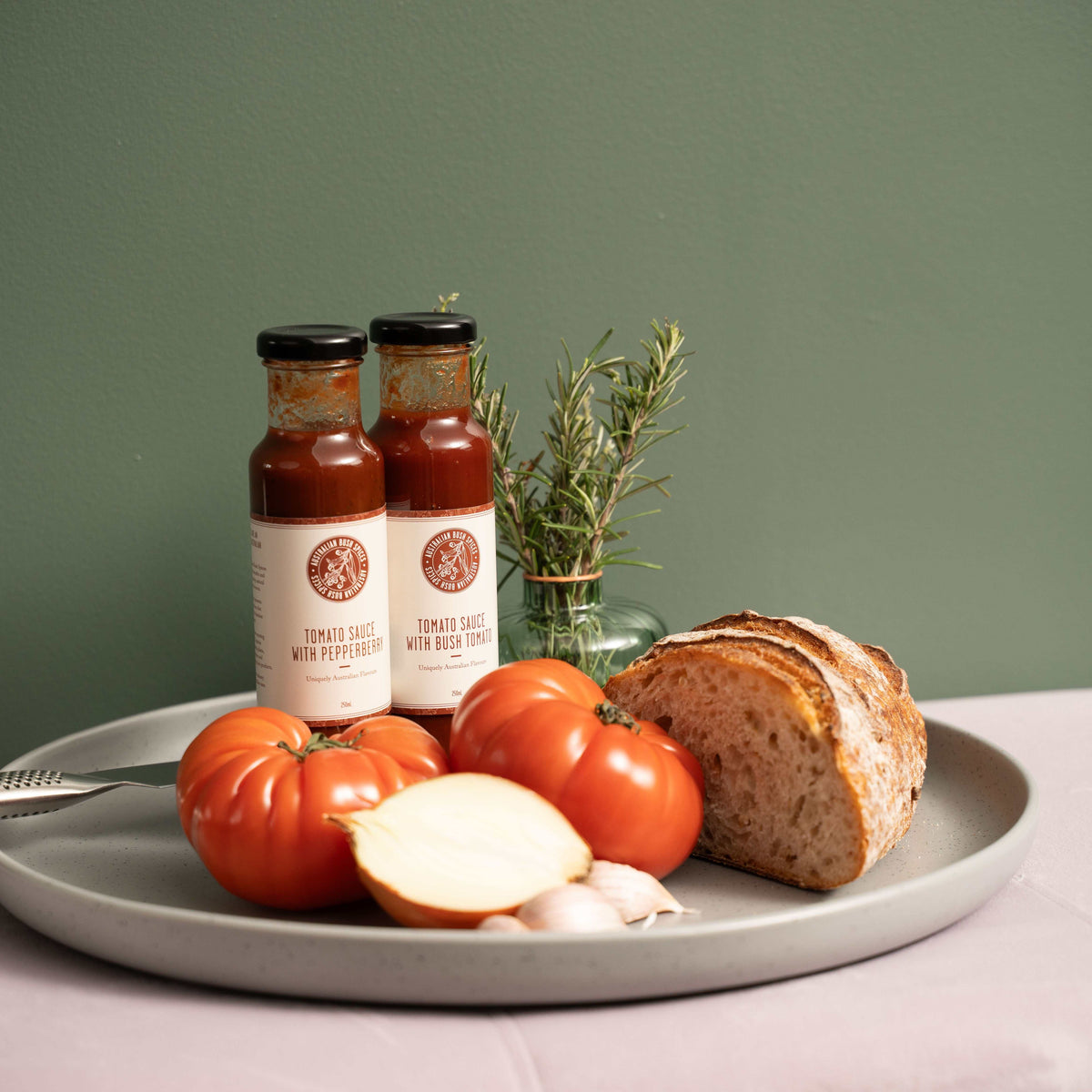 Bottle of Australian Pepperberry Tomato Sauce with fresh tomatoes and pepperberry leaves